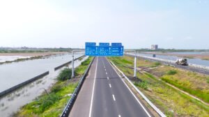 Aerial view of the Ahmedabad–Dholera Expressway with signboards showing exits toward Dholera SIR.